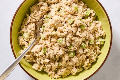 Tuna salad with celery in a bowl displayed with a spoon