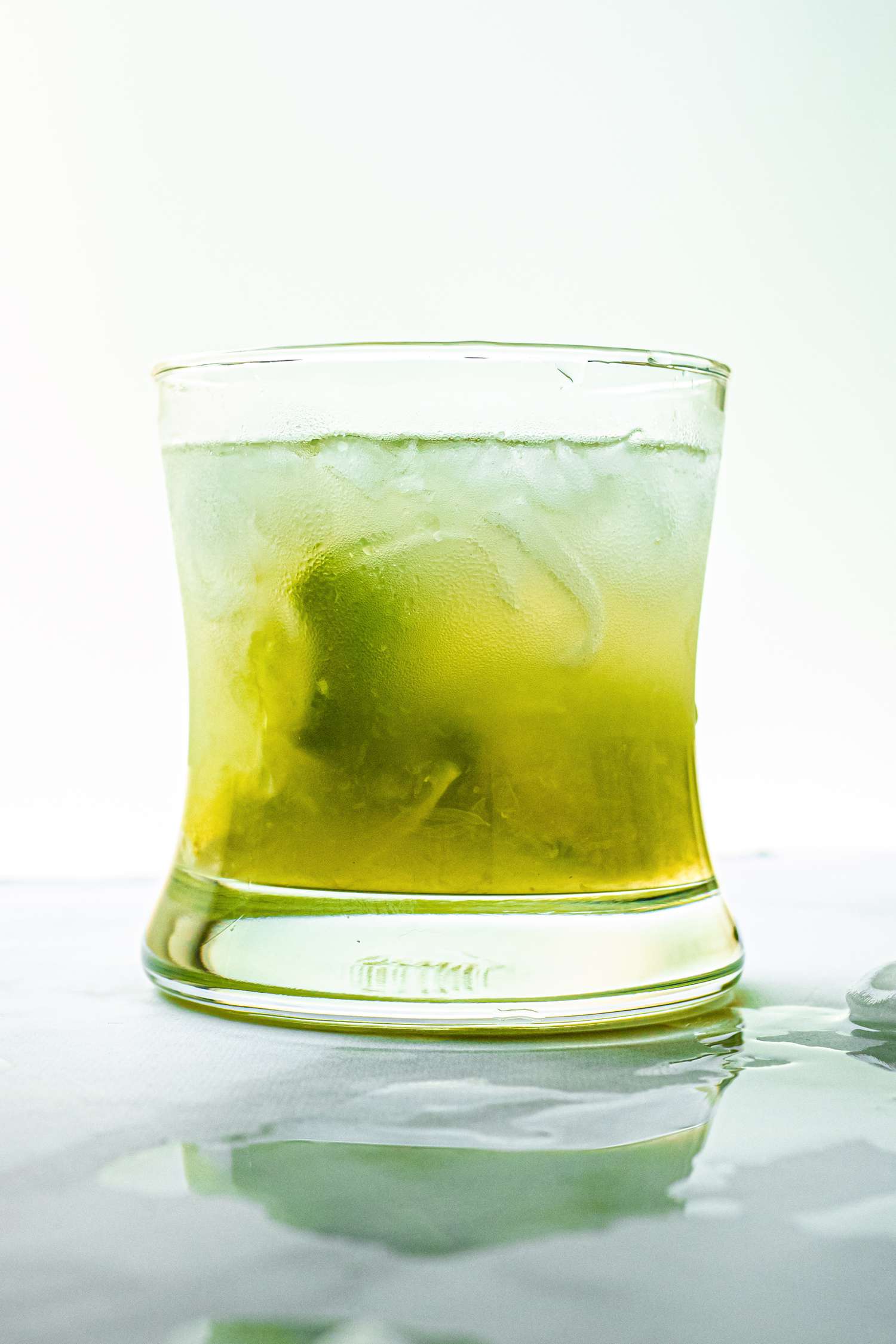 Side view of a sweet and puckery cocktail in a double rocks glass.