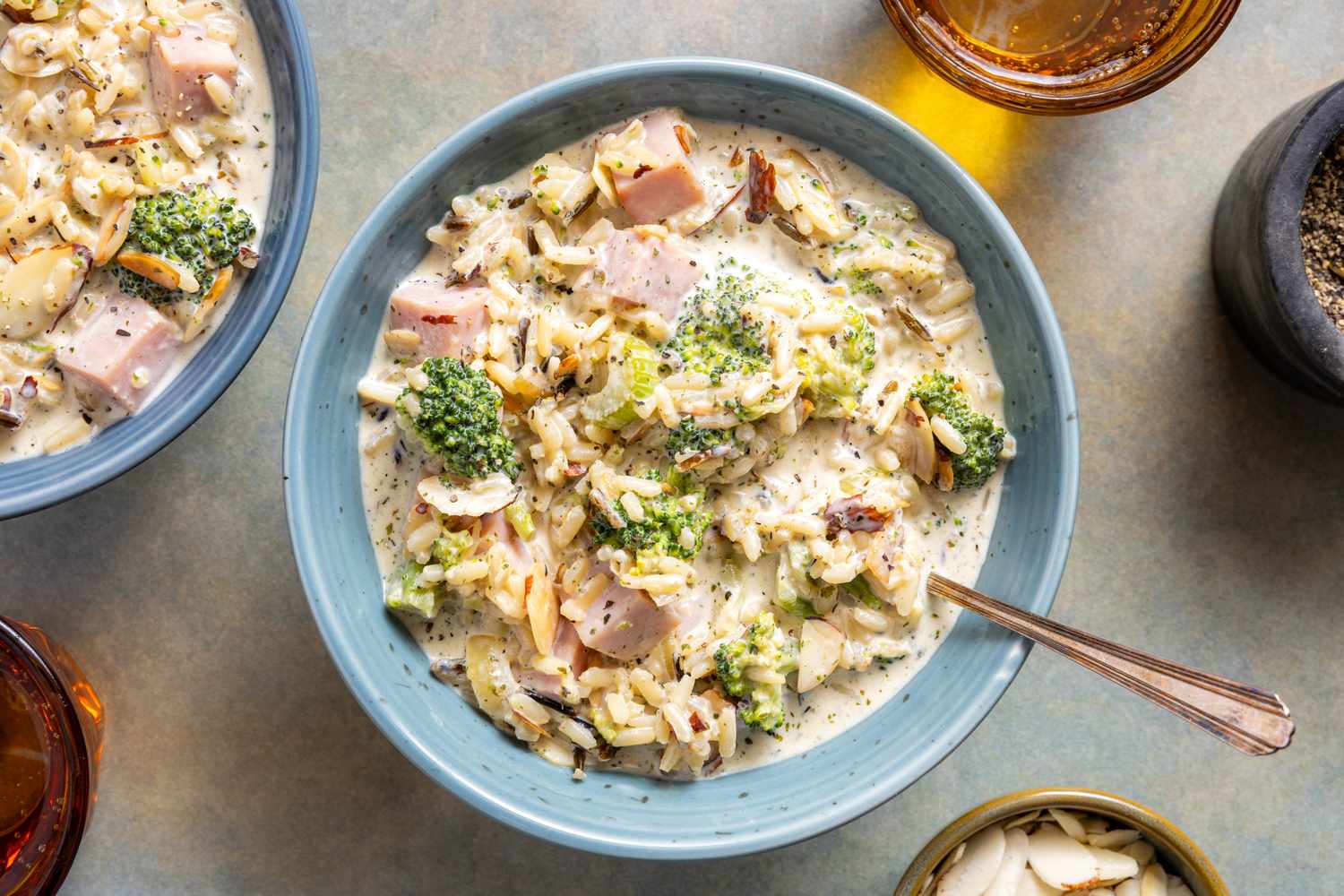 A bowl of creamy broccoli and wild rice soup with garnishes