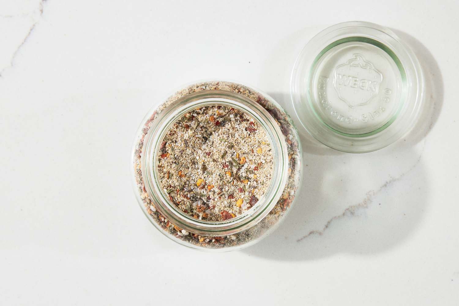 Steak Seasoning in a Jar Next to the Jar Lid on the Counter