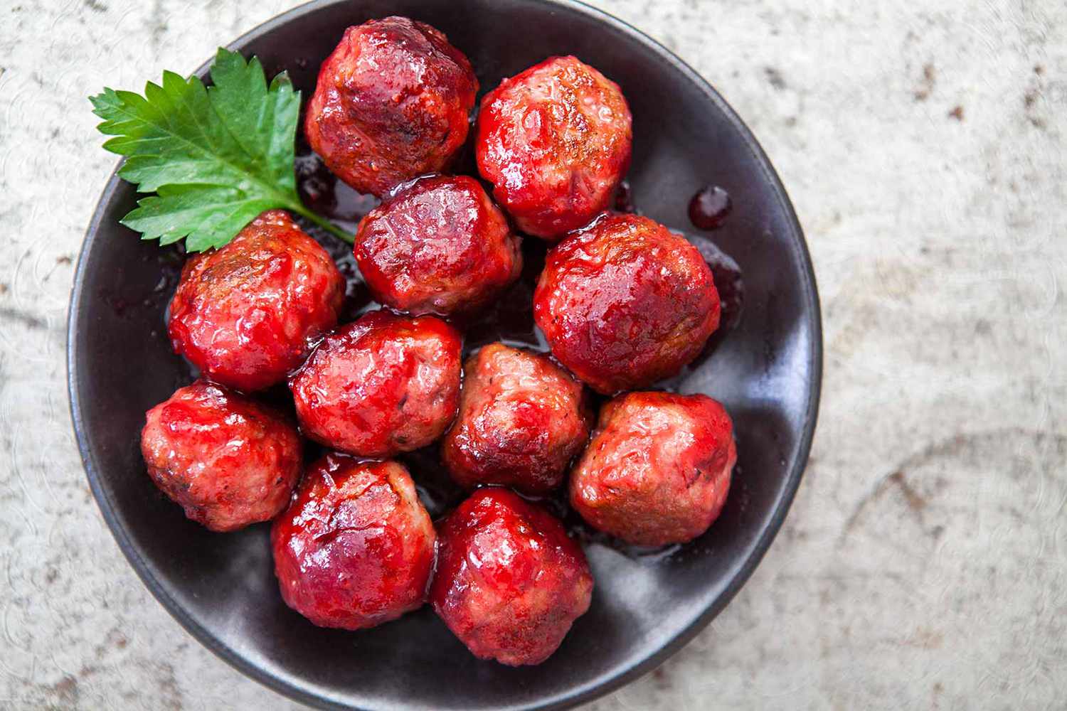 A bowl with cranberry glazed meatballs, ready to serve