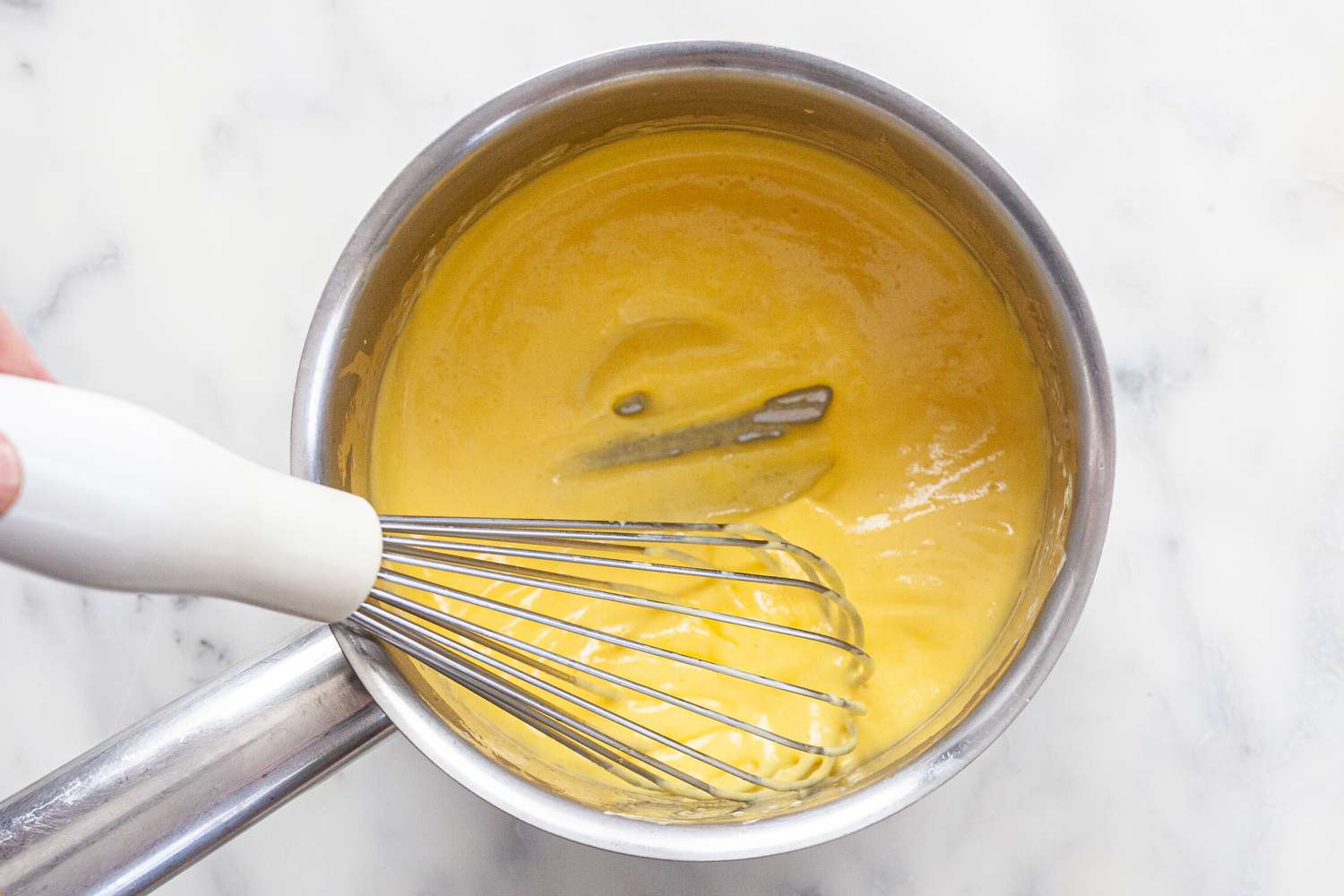 Thickening egg yolks in a sauce pan to show how to make béarnaise sauce.