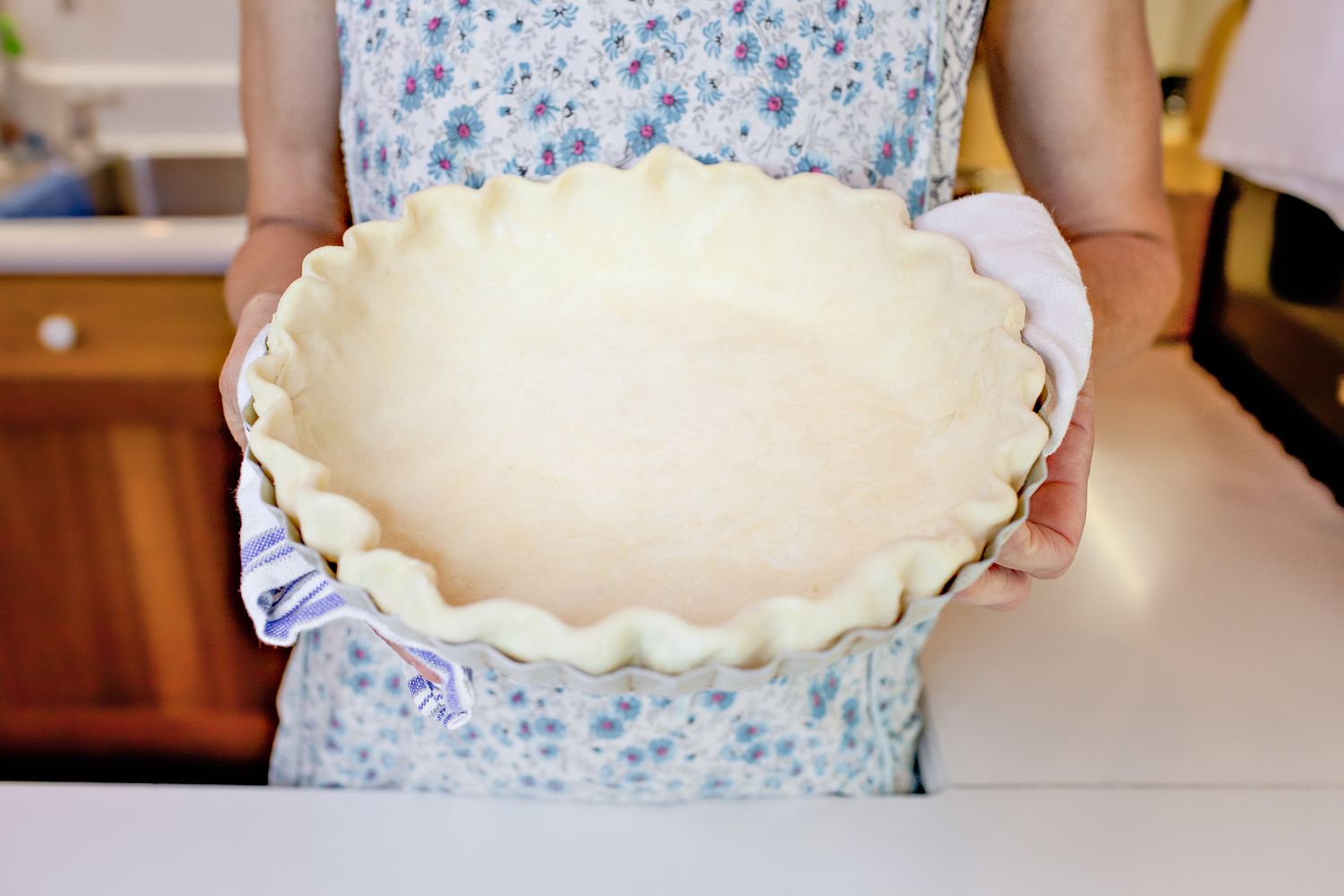 A Person Holding a Pie Dish with Pie Dough Made by Hand