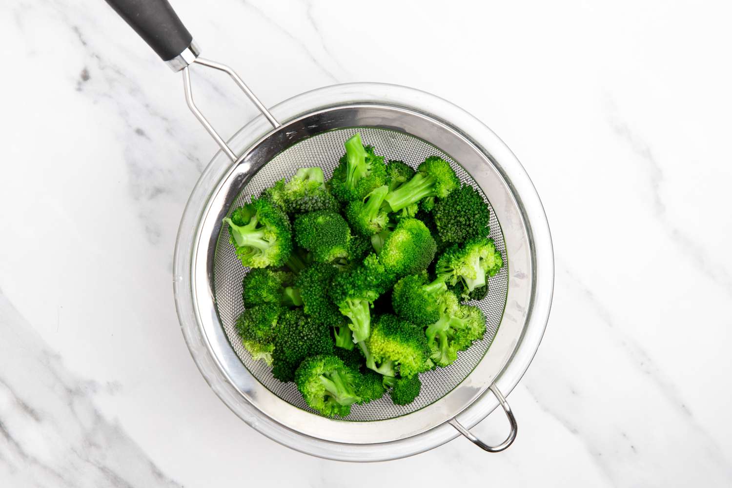 Microwave Steamed Broccoli in a Colander over a Bowl