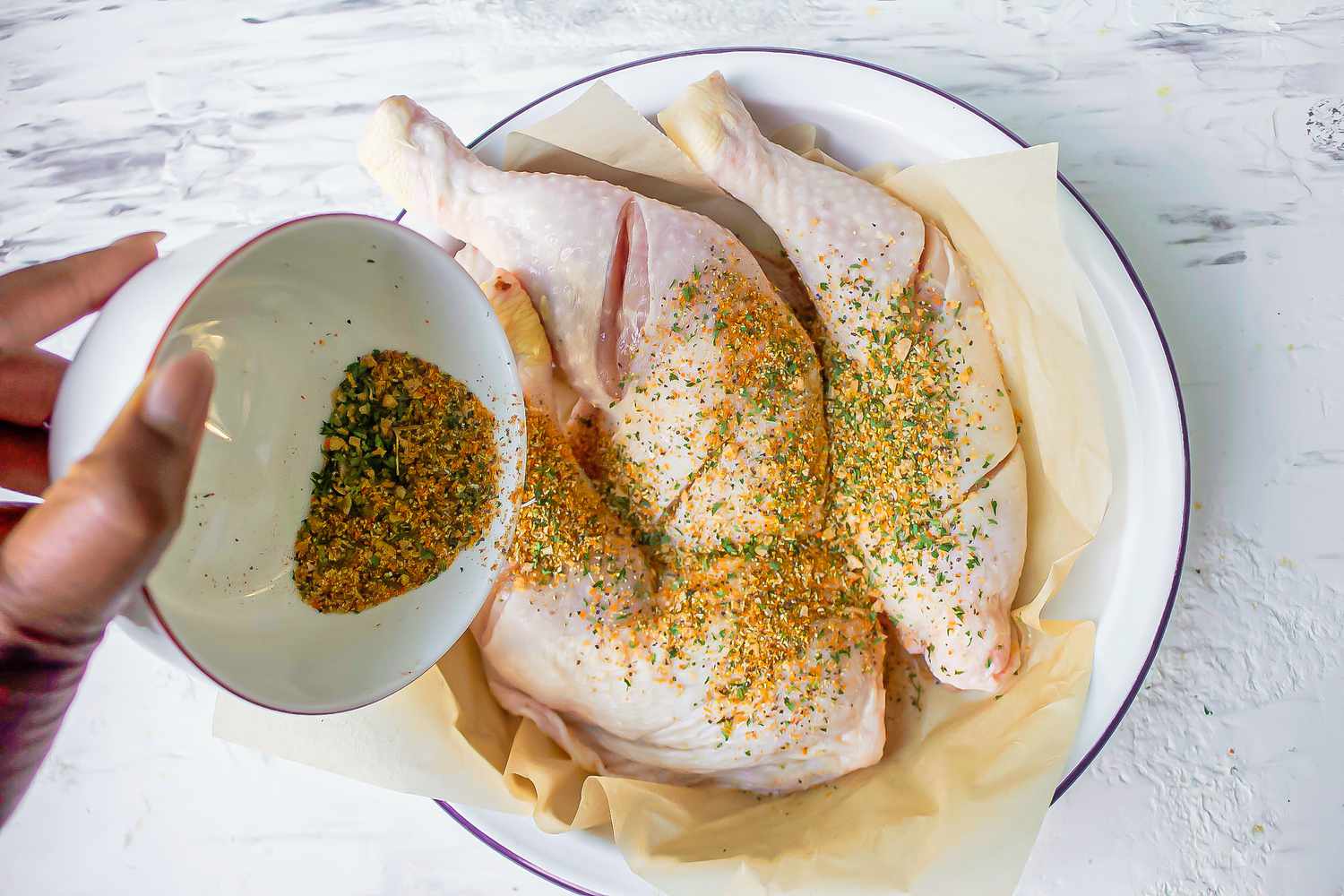 Seasoning the chicken for chicken yassa recipe