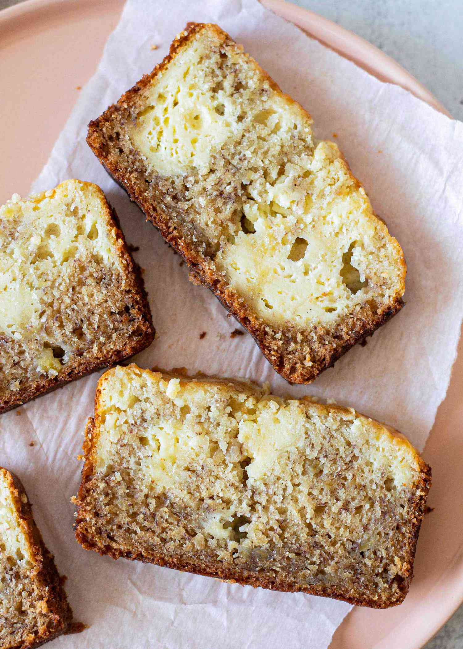 Slices of cream cheese filled banana bread on a plate.
