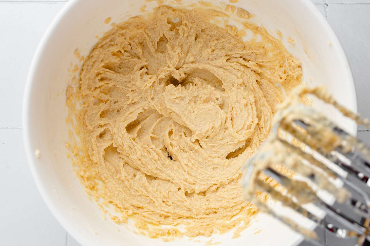 Eggs Mixed into Bowl of Creamed Sugars and Butter for Pecan Turtle Cookie Cup 