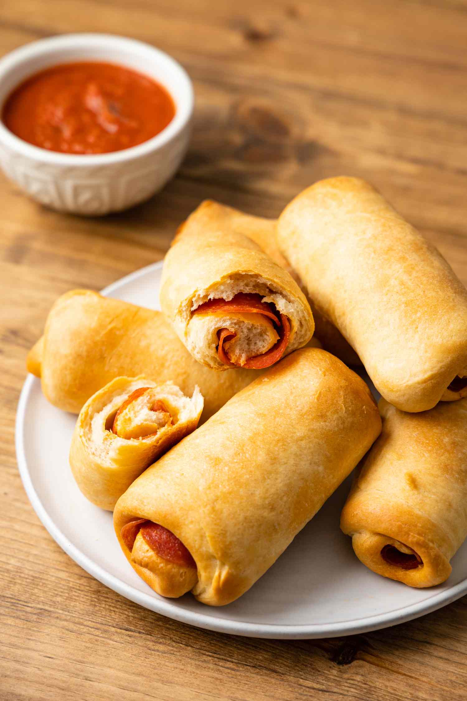 Pepperoni Rolls on a Plate Next to Bowl of Marinara