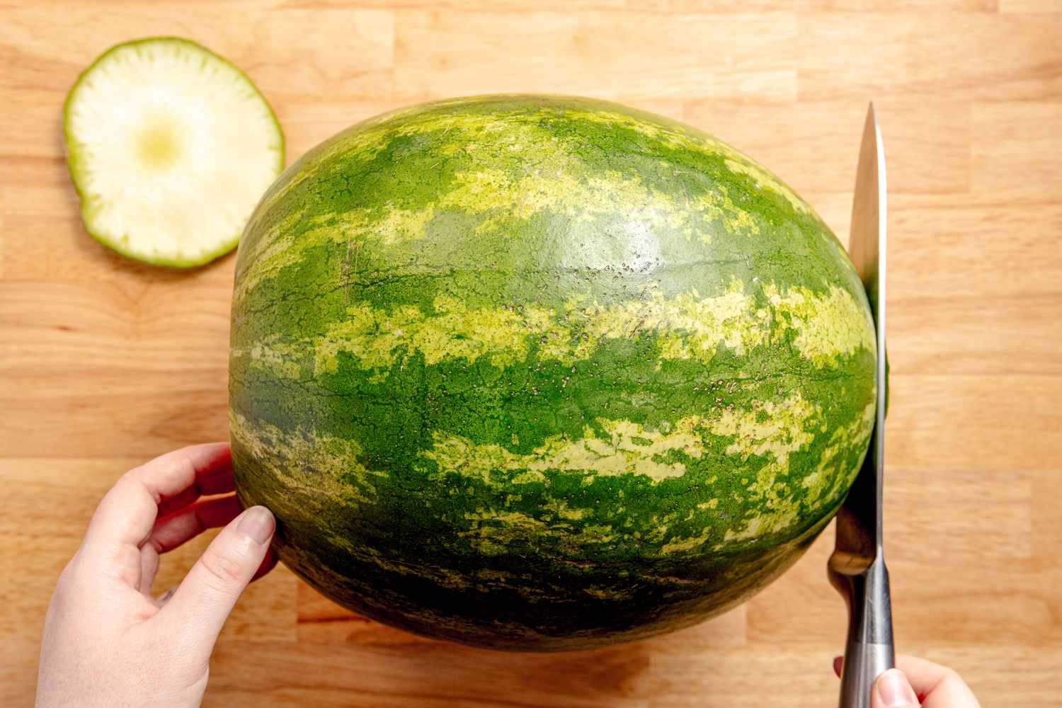 Large Watermelon on a Cutting Board With the Ends Carefully Cut Off Using a Knife for Grilled Watermelon Recipe