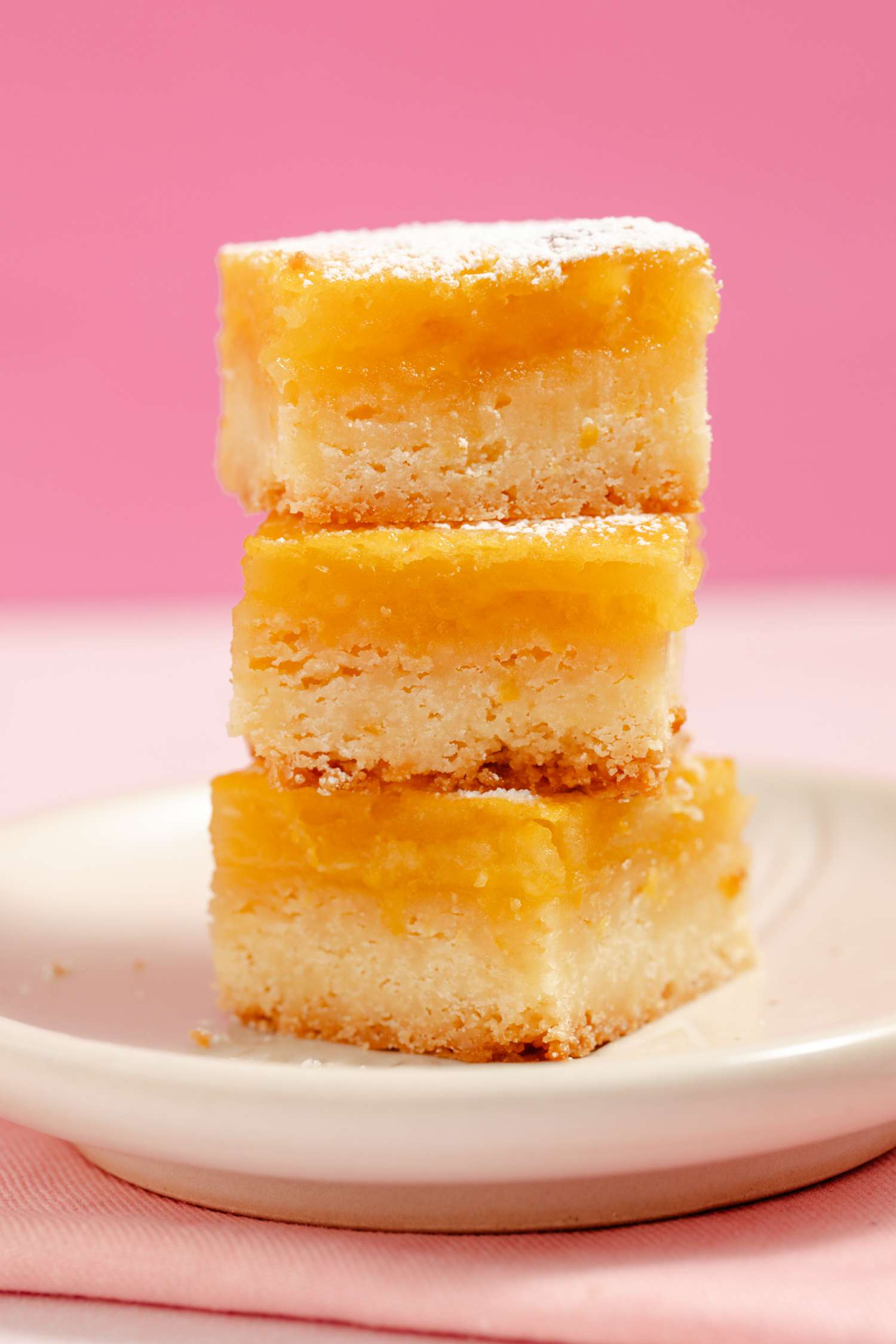lemon bars stacked on a plate