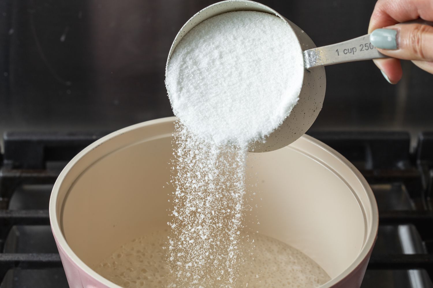 Adding sugar to water to make simple syrup for a ginger beer recipe.
