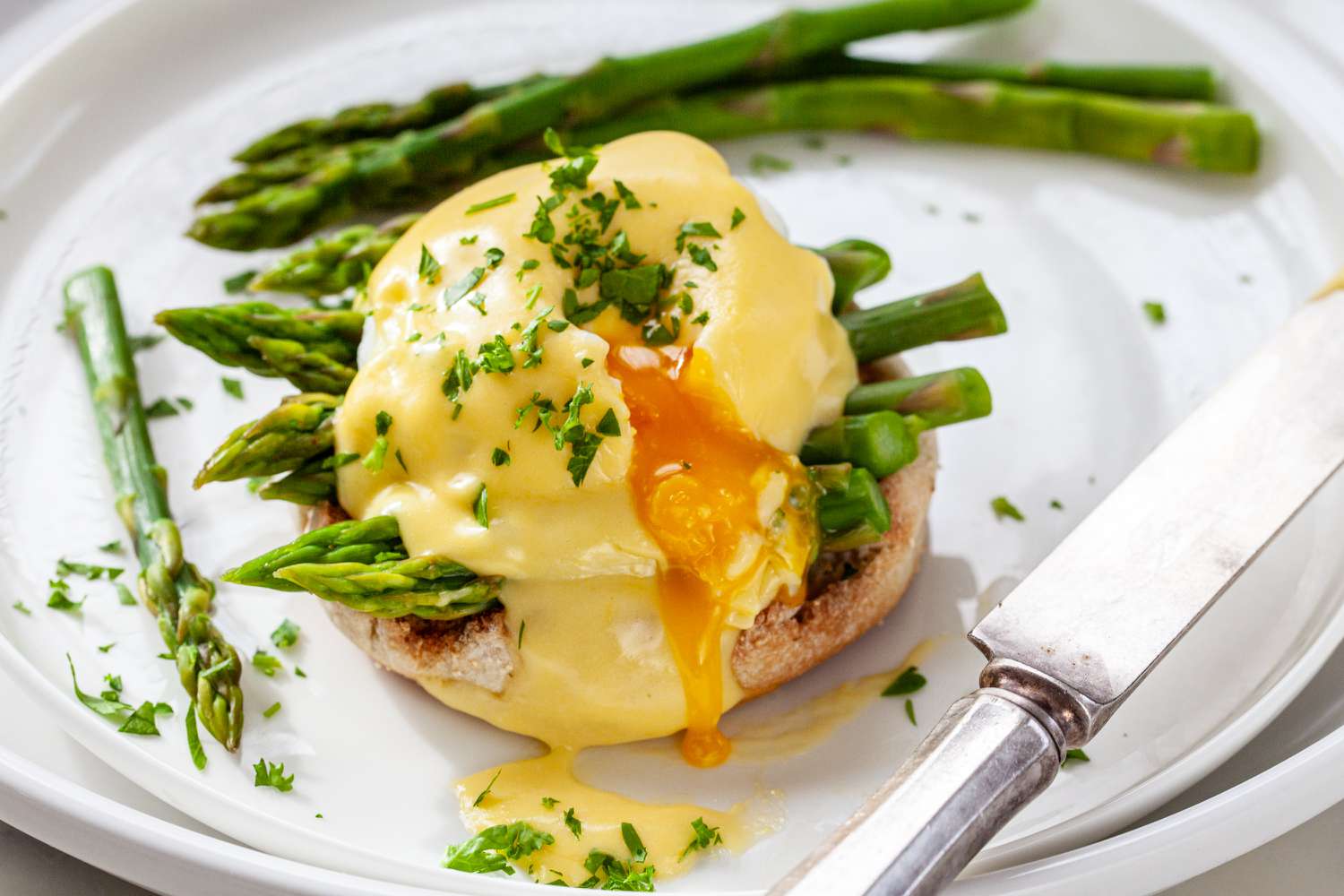 An asparagus egg benedict with 20 Minute Hollandaise Sauce spooned over top.