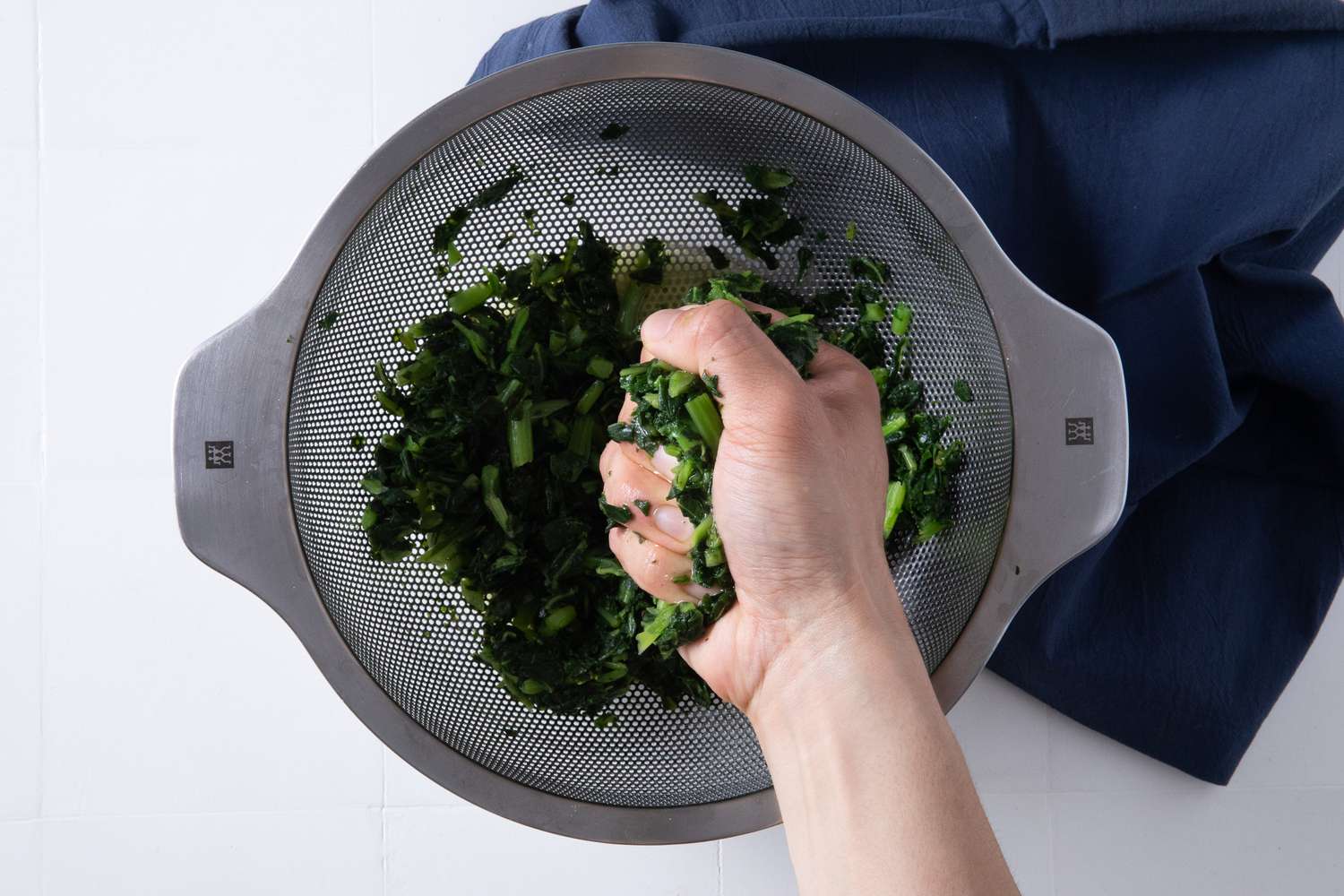 moisture squeezed from frozen kale in a colander for batsaria recipe 