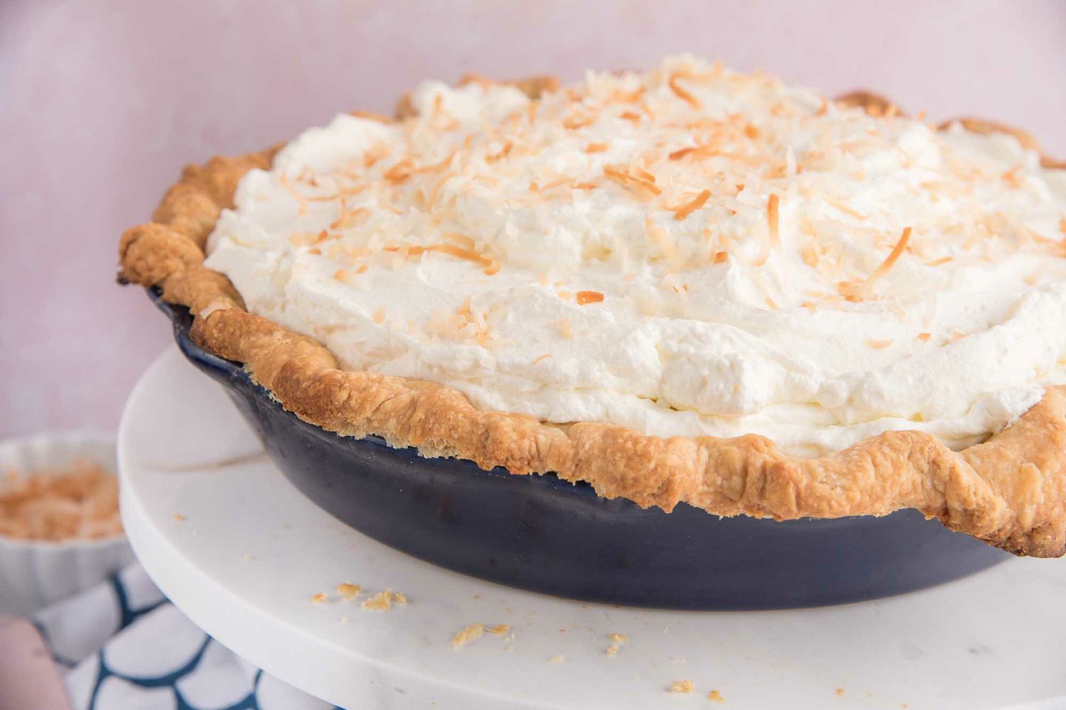 Side view of an easy coconut cream pie on a cake stand.