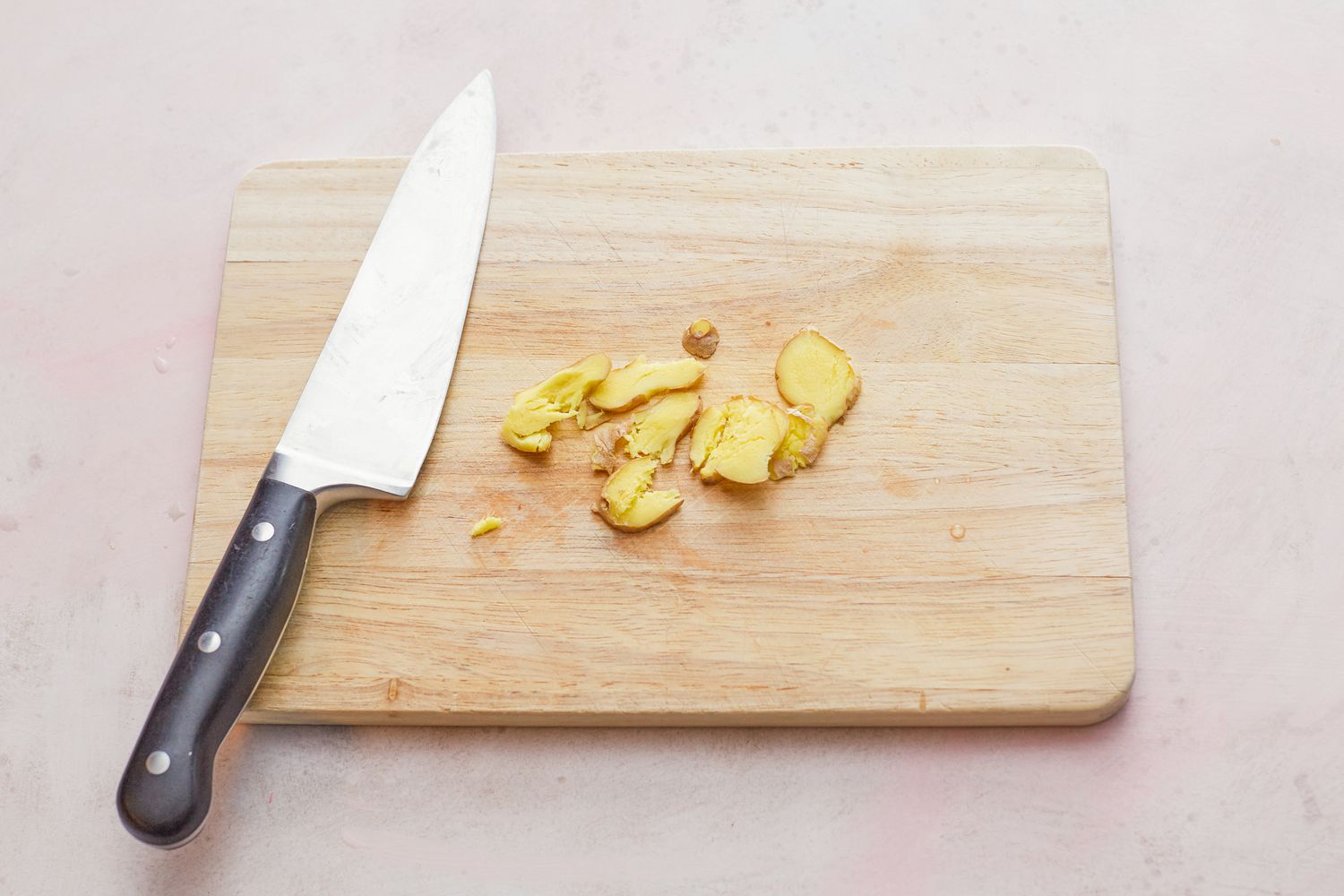Prepping ginger with a chef's knife to make whole steamed black sea bass
