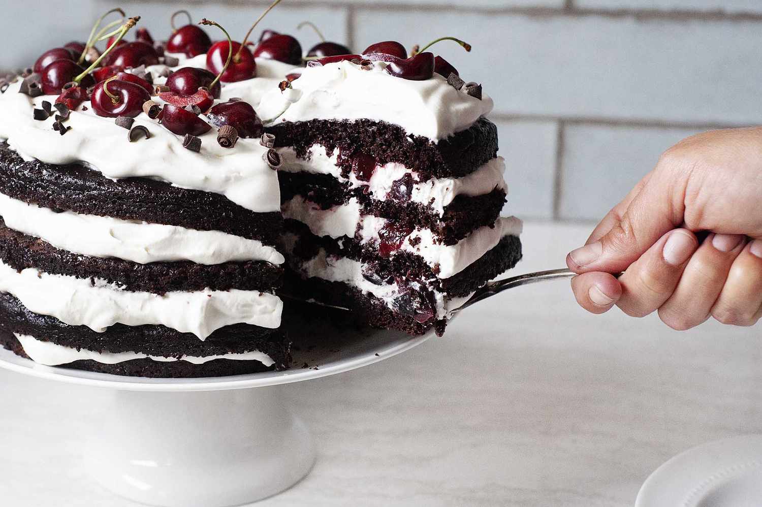 Homemade Black Forest Cake with a slice being removed.