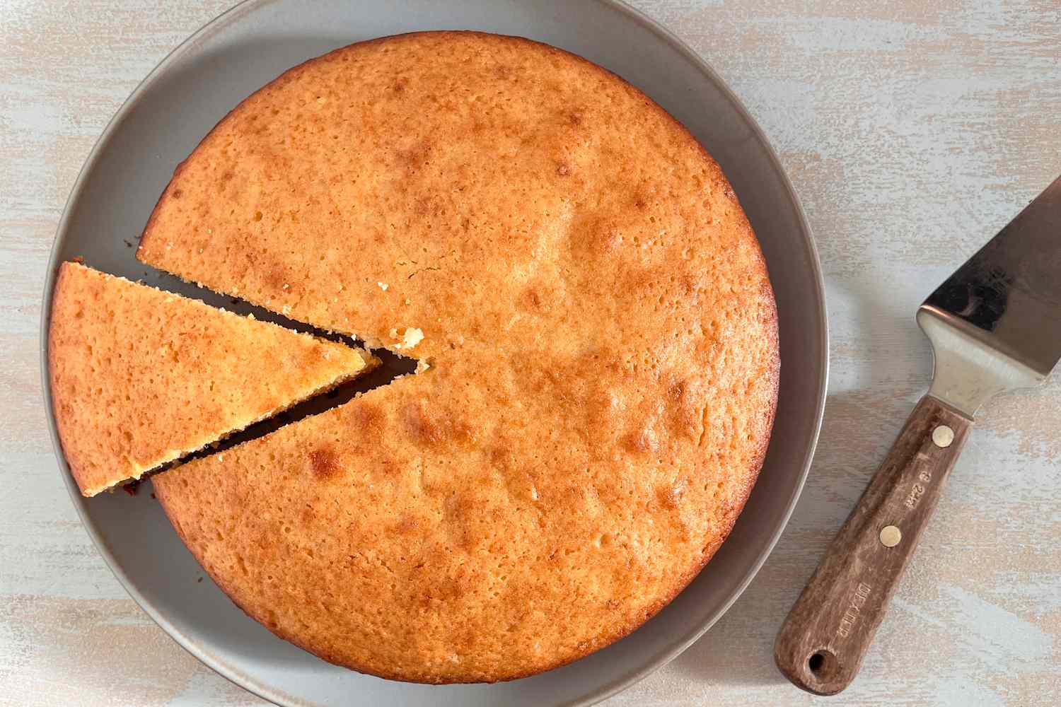 Overhead shot: French yogurt cake on a plate with a slice cut 