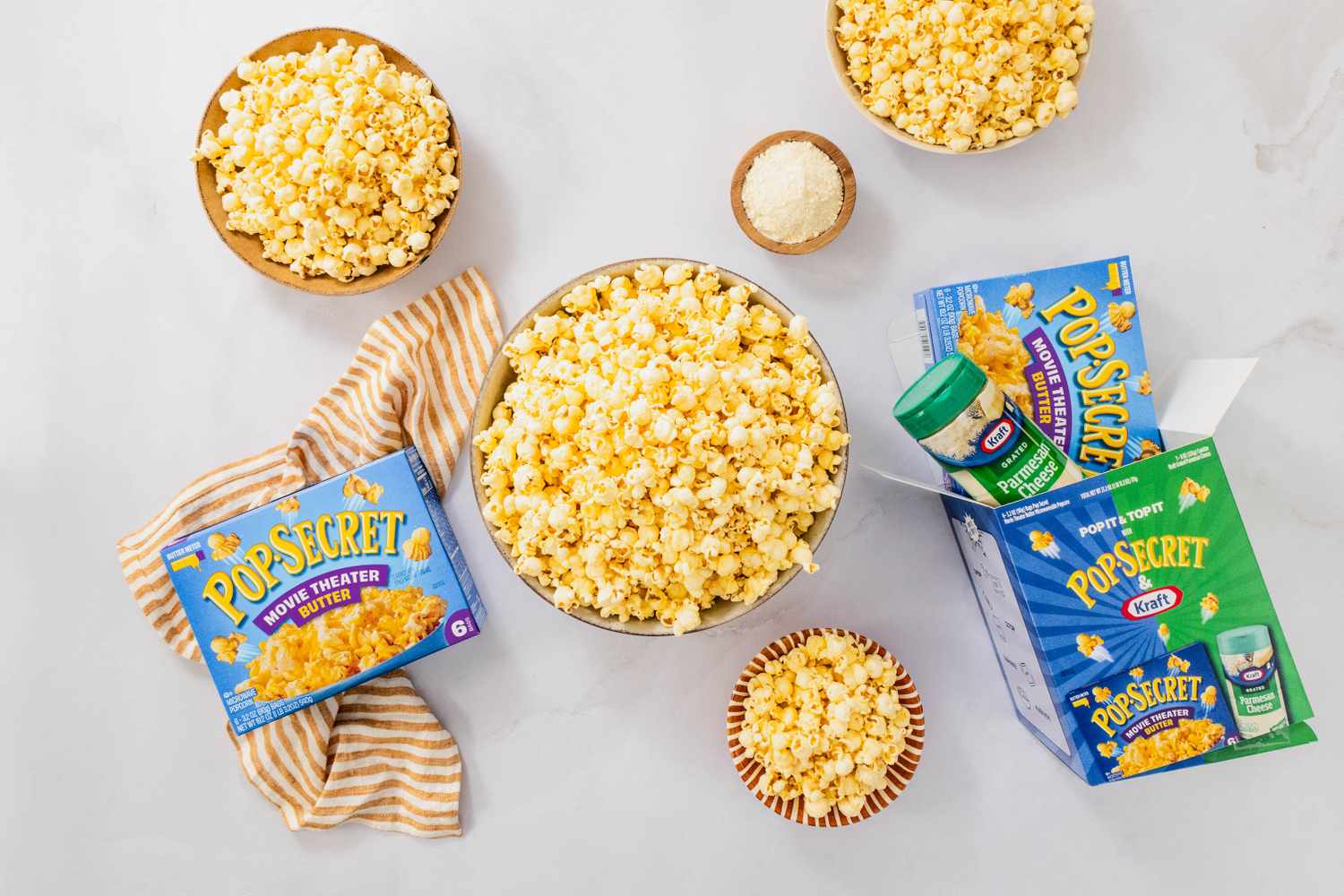 Popcorn in bowls surrounded by Pop Secret microwave popcorn boxes and seasoning