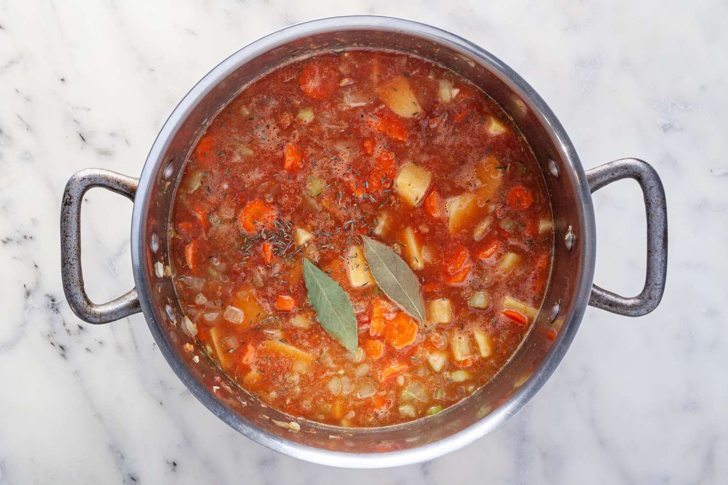 Manhattan Clam Chowder beginning to simmer in a pot to make the best chowder recipe