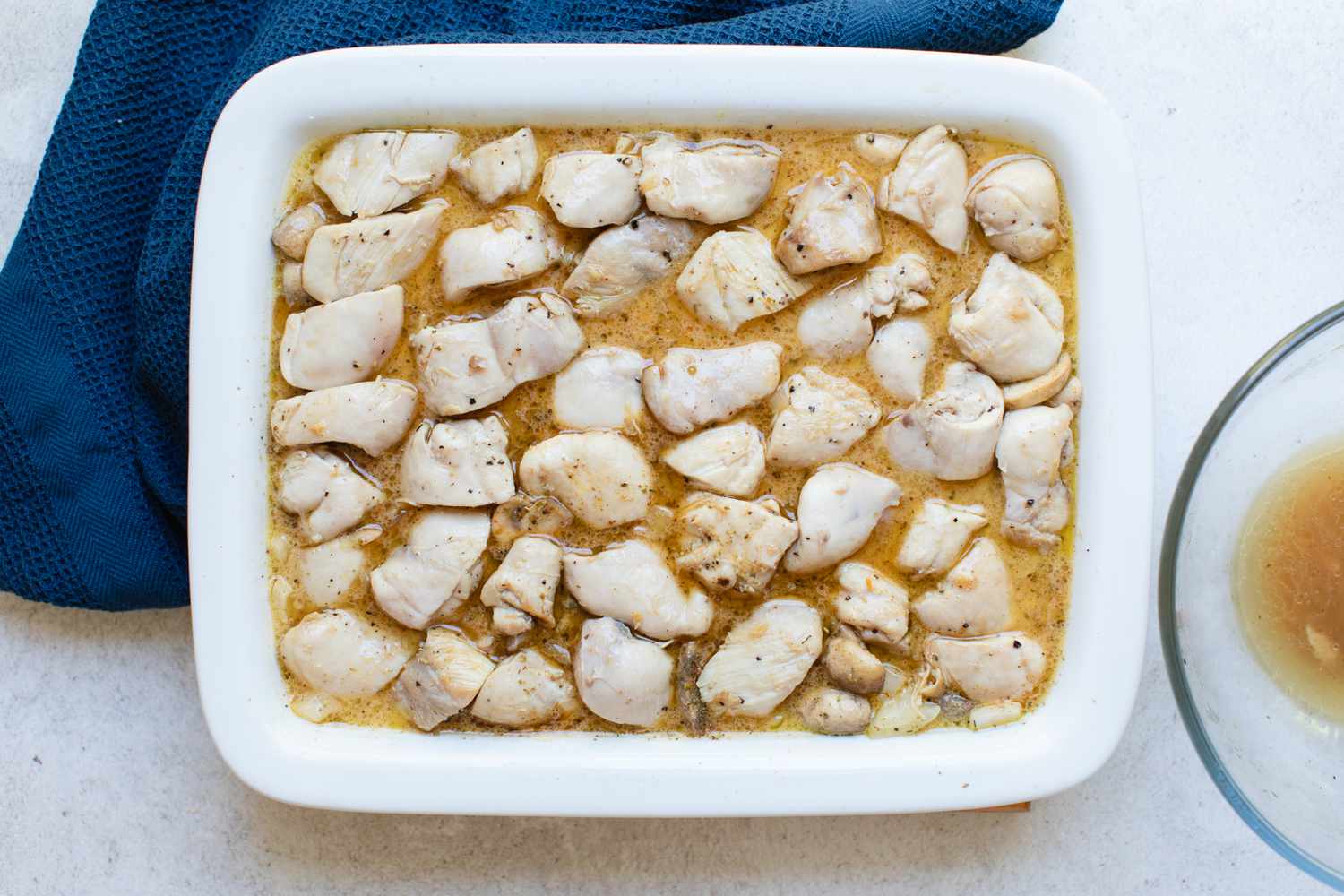 Chicken pieces on top of a chicken and rice casserole, ready to bake