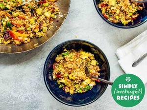 Vegetable fried rice in a blue bowl with a fork