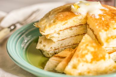 A stack of fluffy pancakes cut so that the inside layers are visible