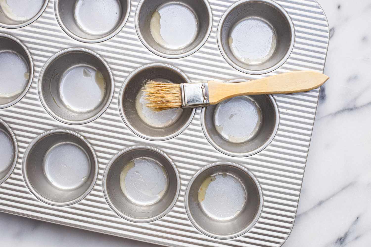 Muffin Tin Buttered Using a Pastry Brush