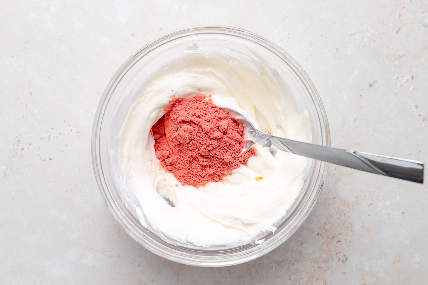 Stirring in powdered strawberries to make strawberry buttercream for macarons.