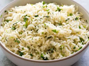 Bowl of cooked rice with cilantro and lime