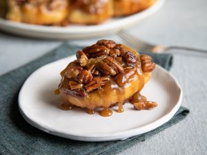 Cinnamon buns with pecans on a plate.