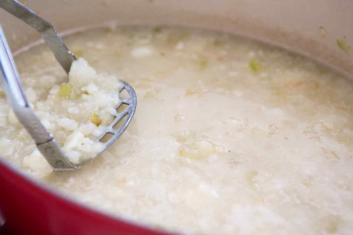Making potato soup in red stockpot