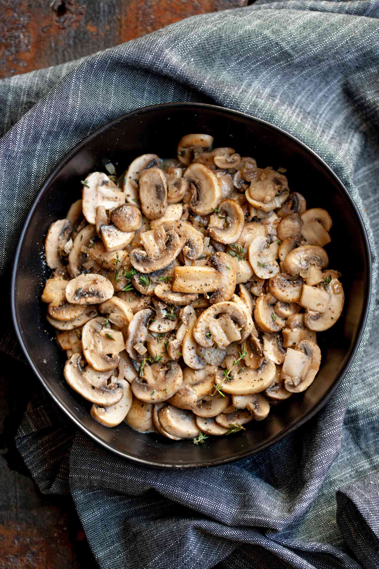 Sautéed mushrooms in black bowl.