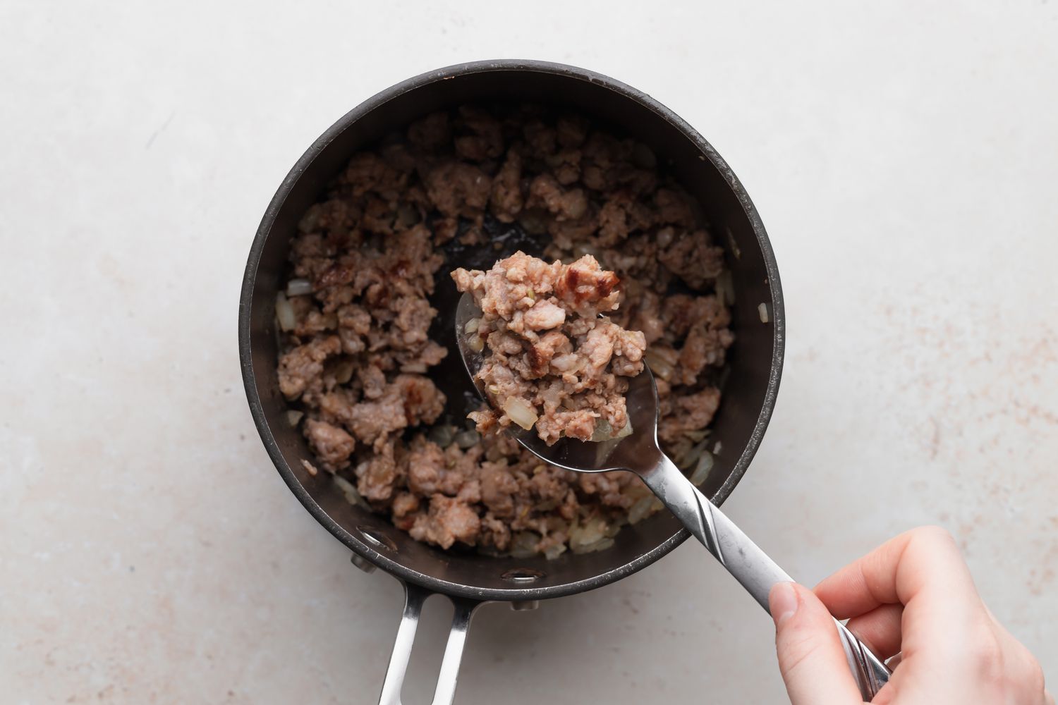 Sausage browned in a pot to show how to make biscuits and gravy