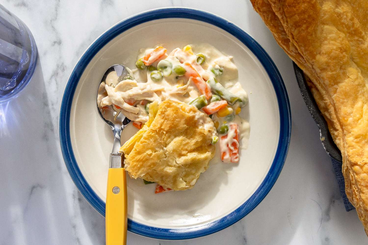 A plate containing chicken pot pie with a serving utensil nearby