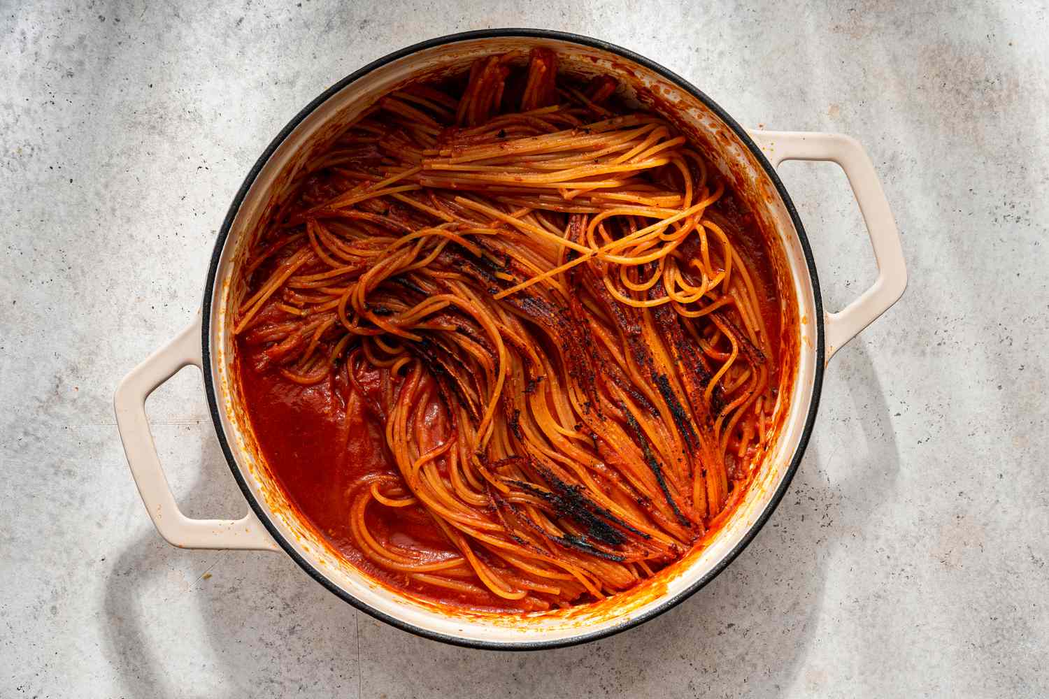 Spaghetti with charred bits after the pasta is flipped for assassin's spaghetti recipe