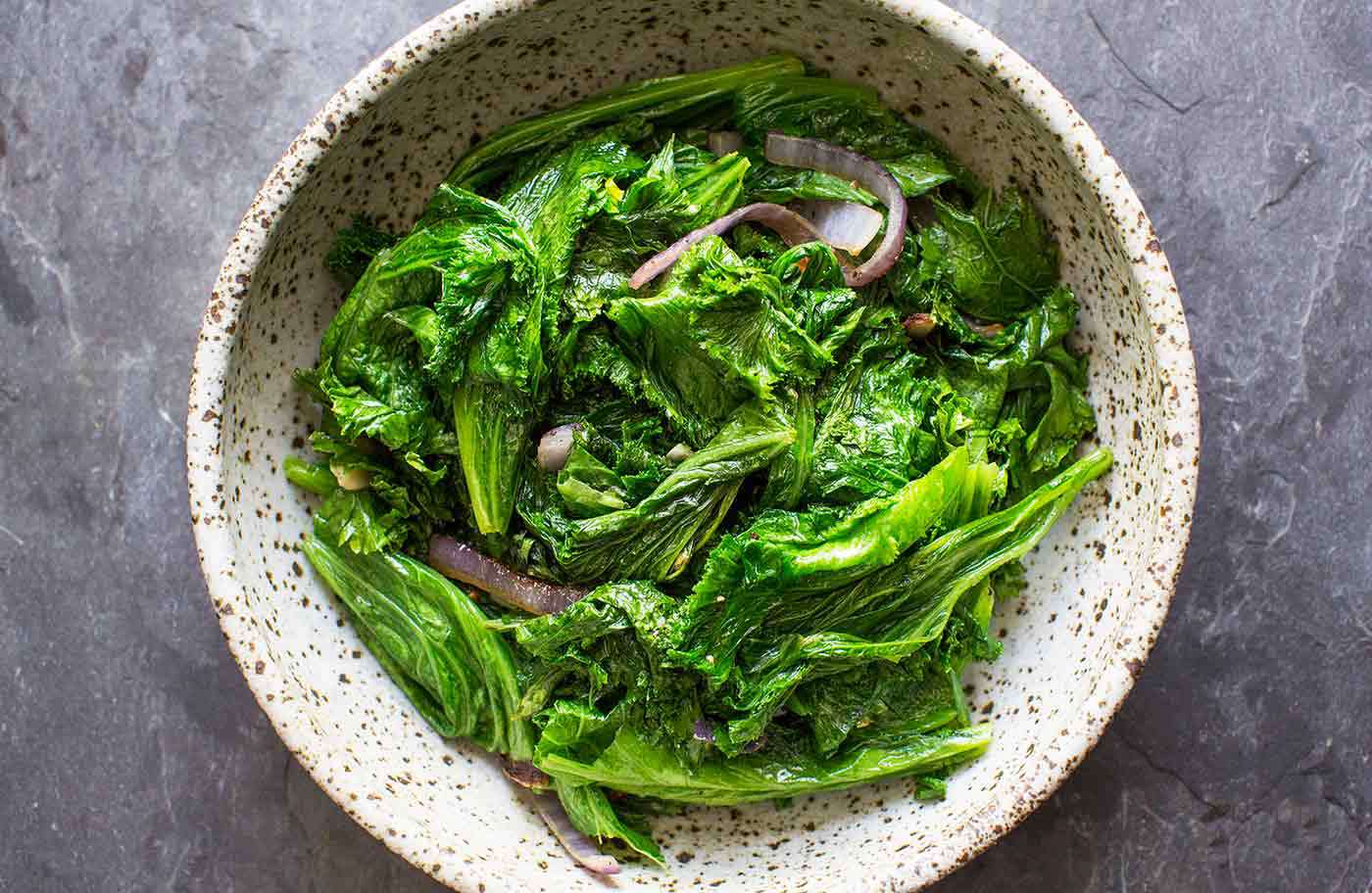 A bowl of mustard greens, ready to serve and eat.