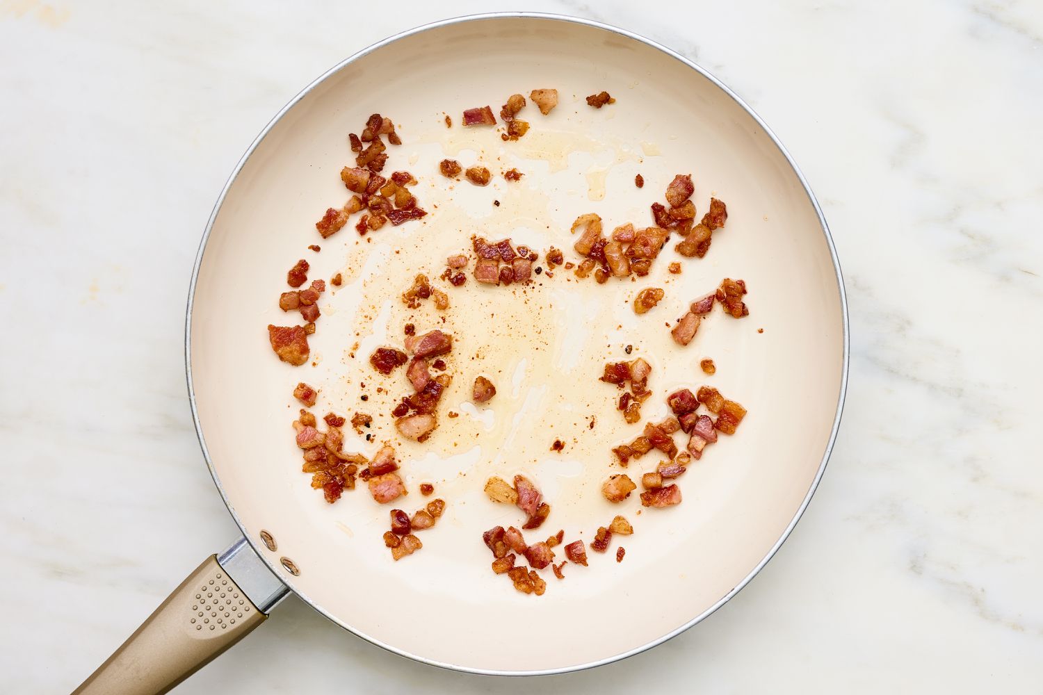 Diced pancetta cooked on a skillet for Creamy Skillet Shrimp with Corn, Pancetta, and Tomatoes recipe