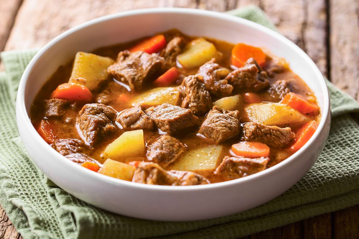 A white bowl with beef stew