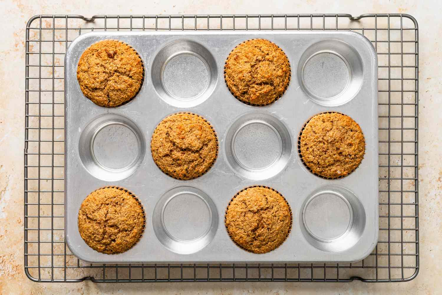 Baked bran muffins in the muffin tray on a cooling rack