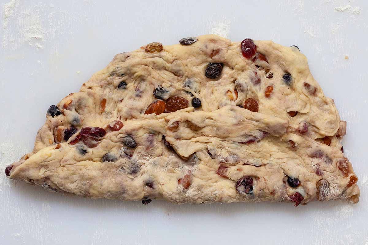 Stollen Christmas Bread dough filled with rum-soaked dried fruit folded in half.