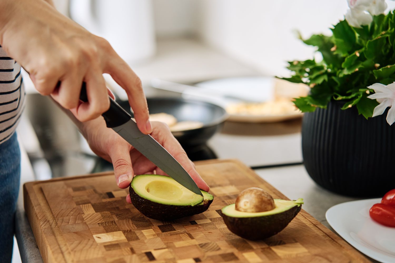 hand cutting an avocado