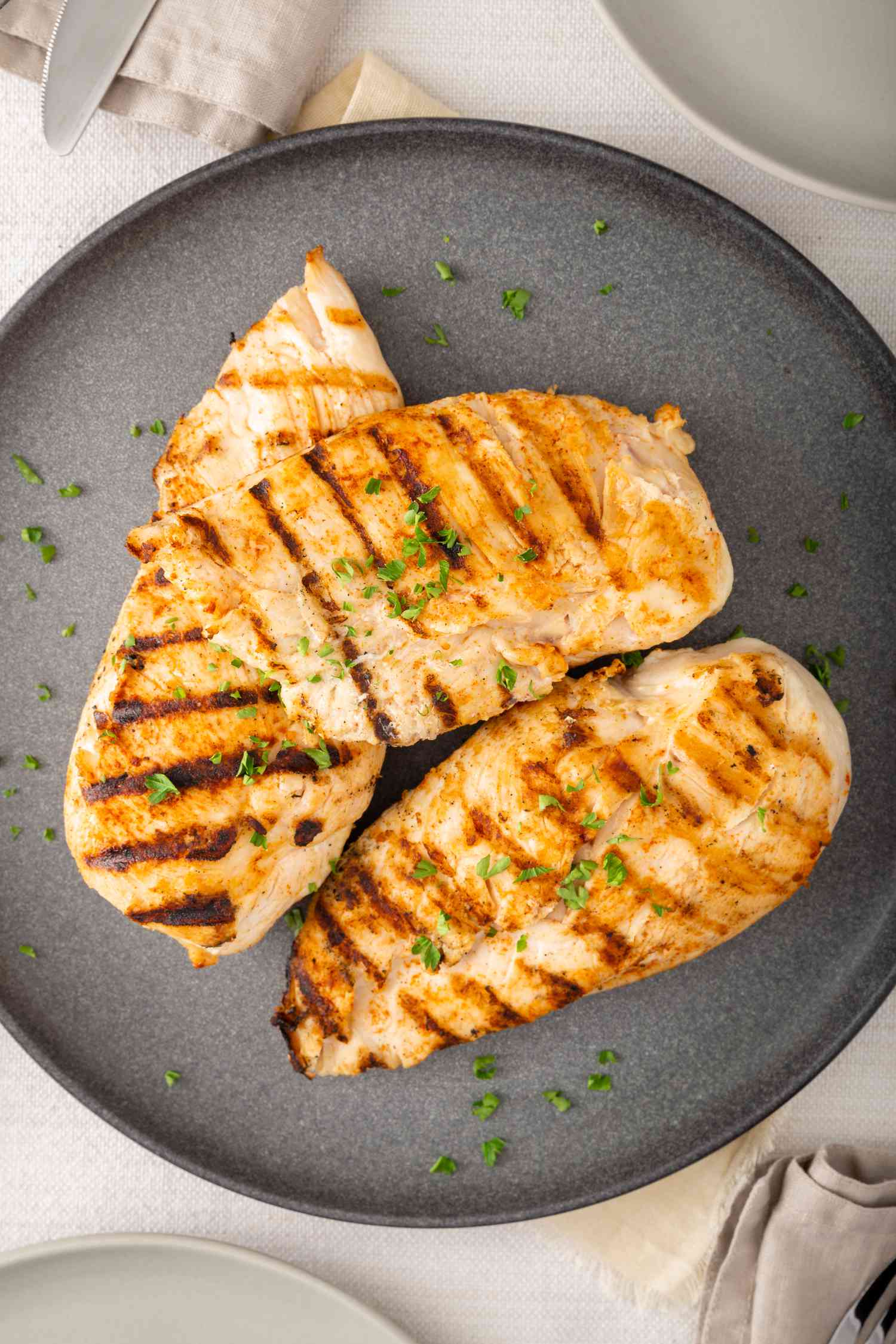 Overhead view of grilled and brined chicken on a plate.