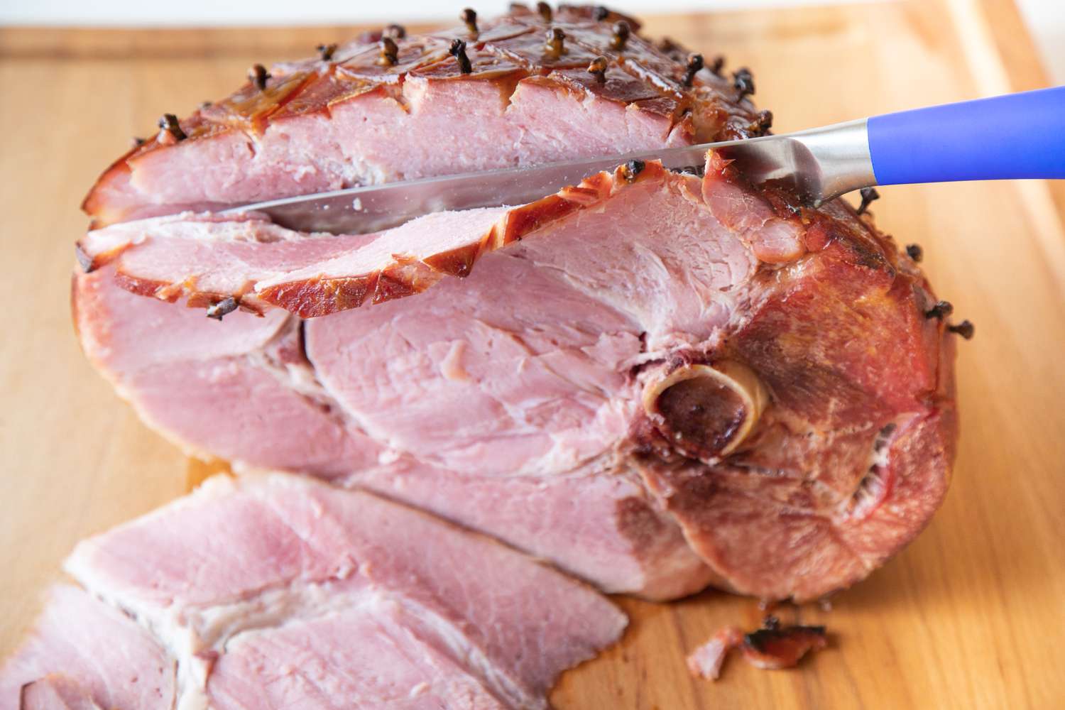 How to cook ham in the oven and slice it on a cutting board.