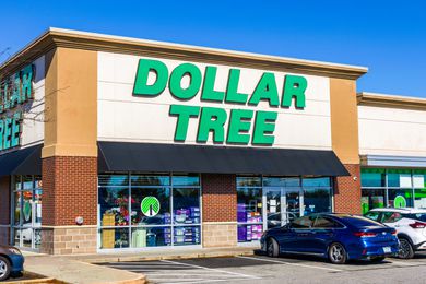 Storefront of a Dollar Tree retail location with parked cars visible