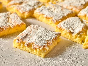 Squares of powdered sugar topped bar dessert arranged closely