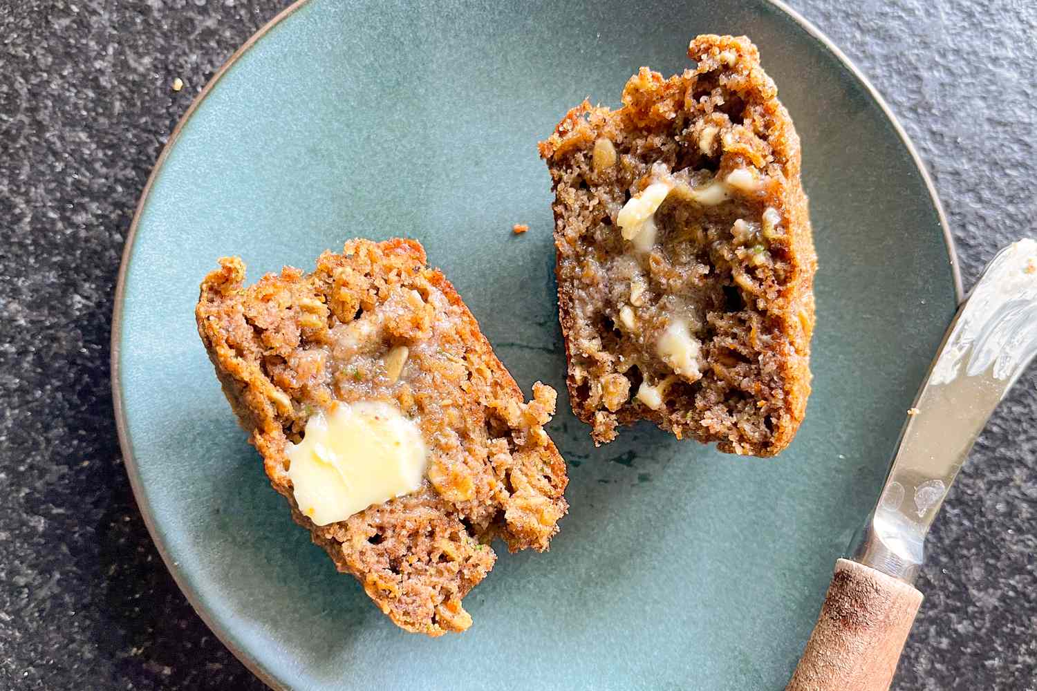 on a plate, halved superhero muffins smeared with a bit of butter