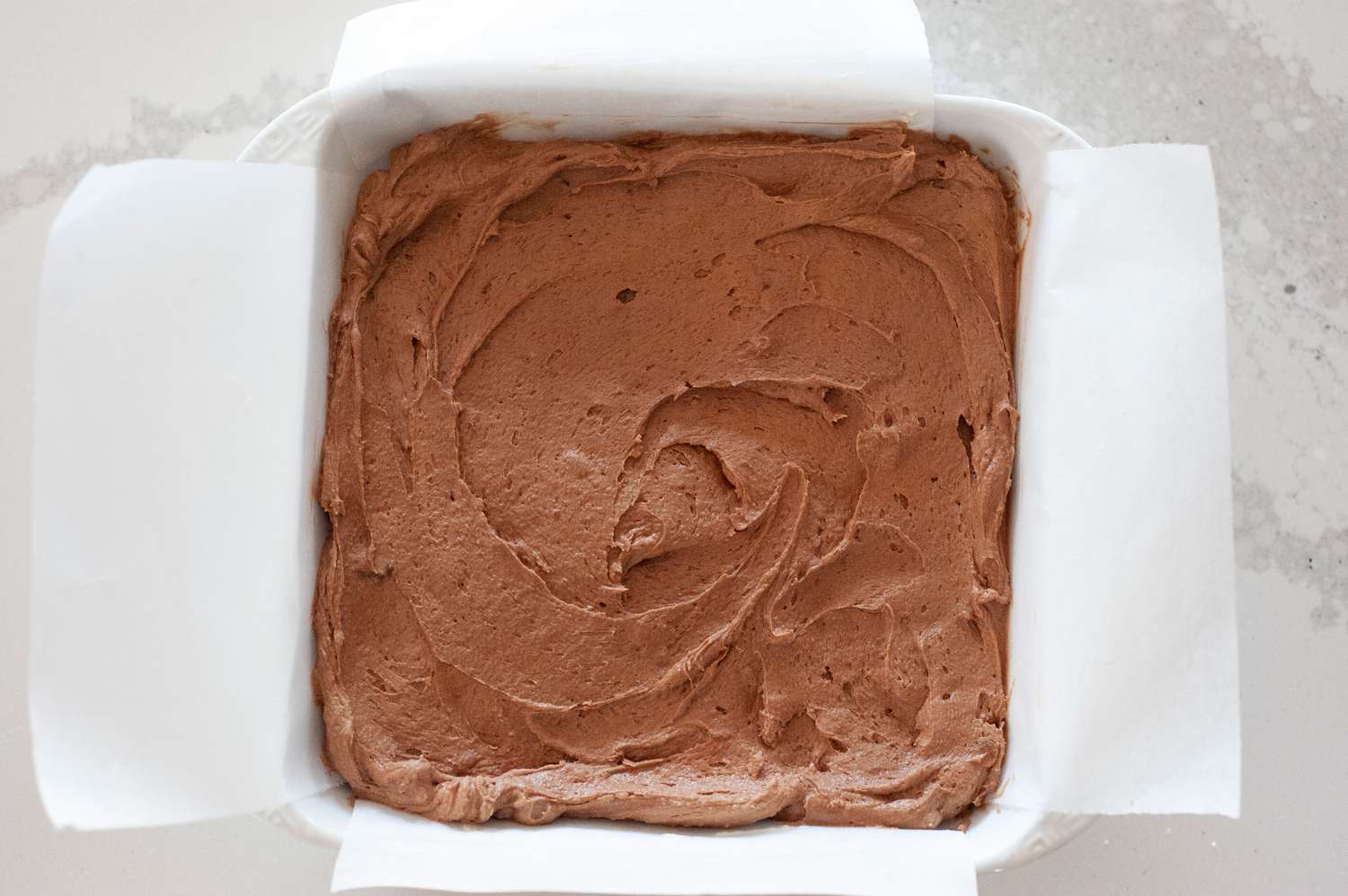 Brownie batter in the cake pan.