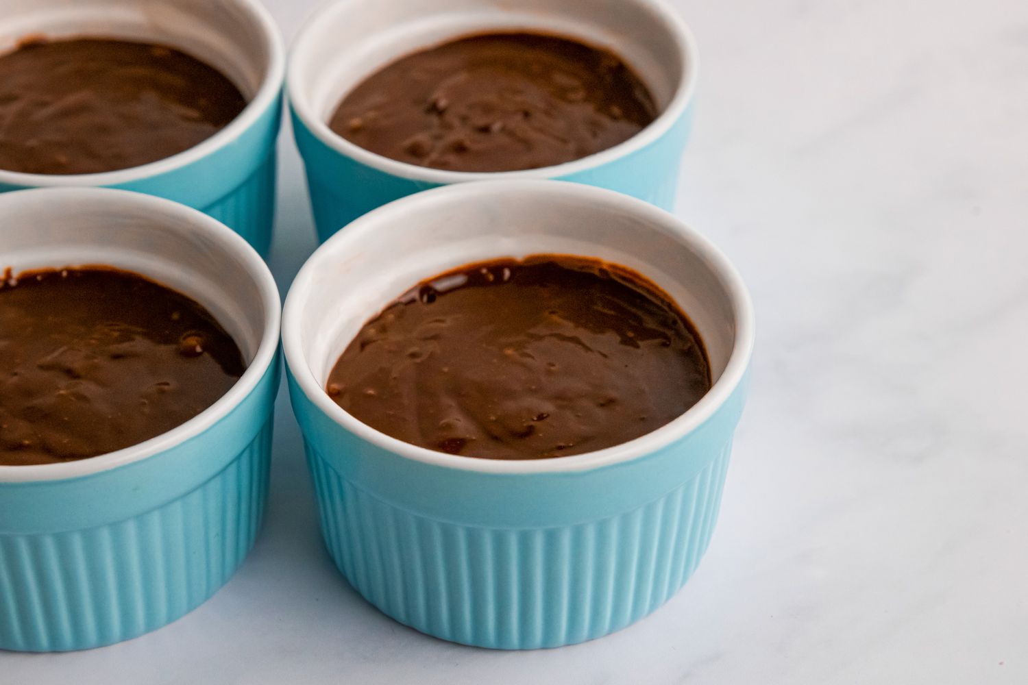 Chocolate batter in greased ramekins.