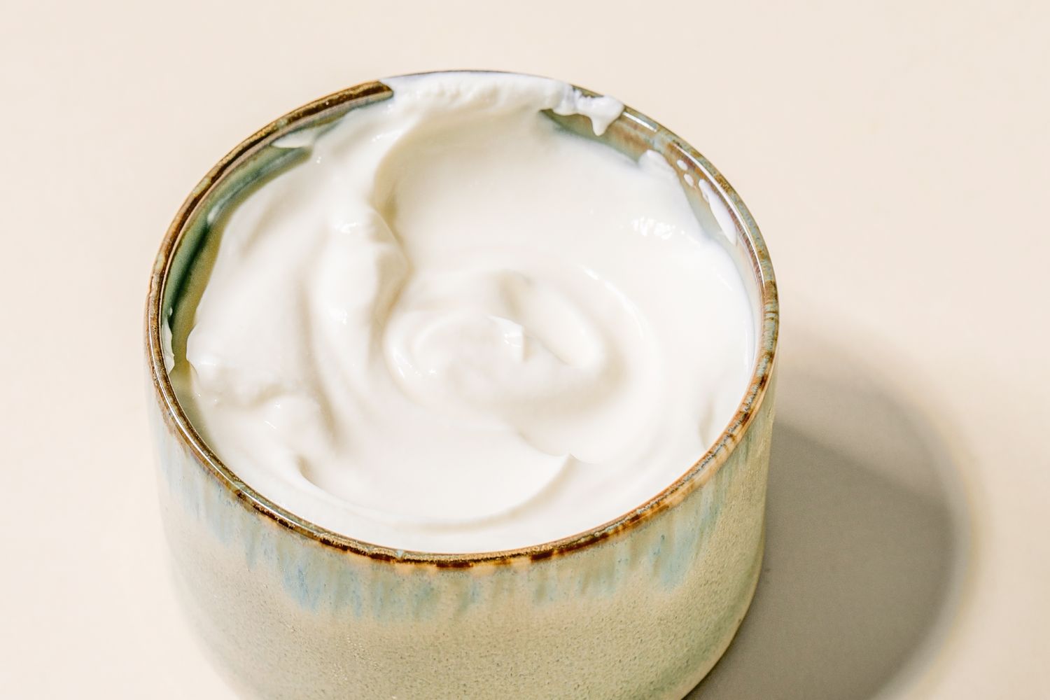 A bowl of creamy mashed potatoes on a light background