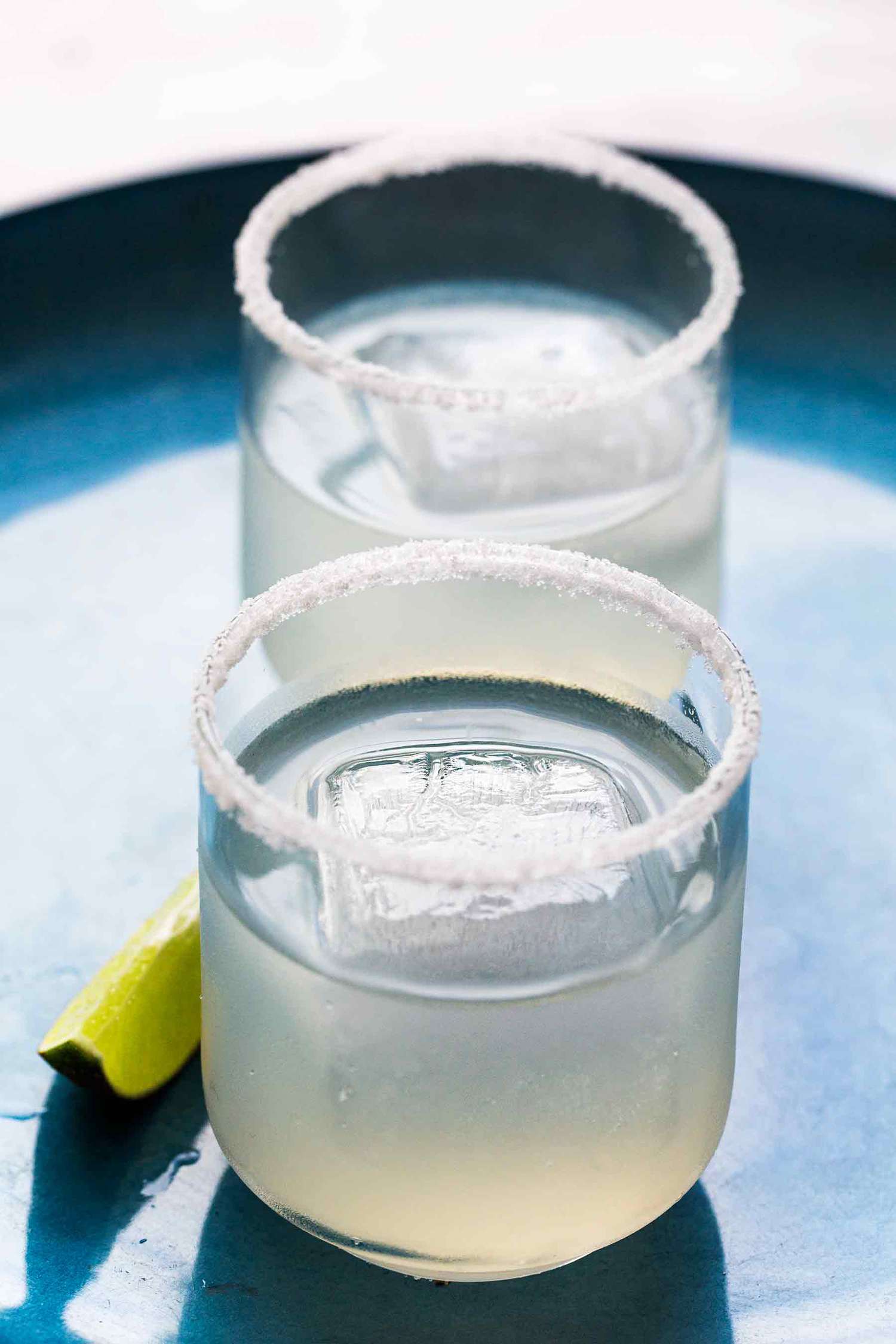 Two classic margaritas in glasses with salted rims